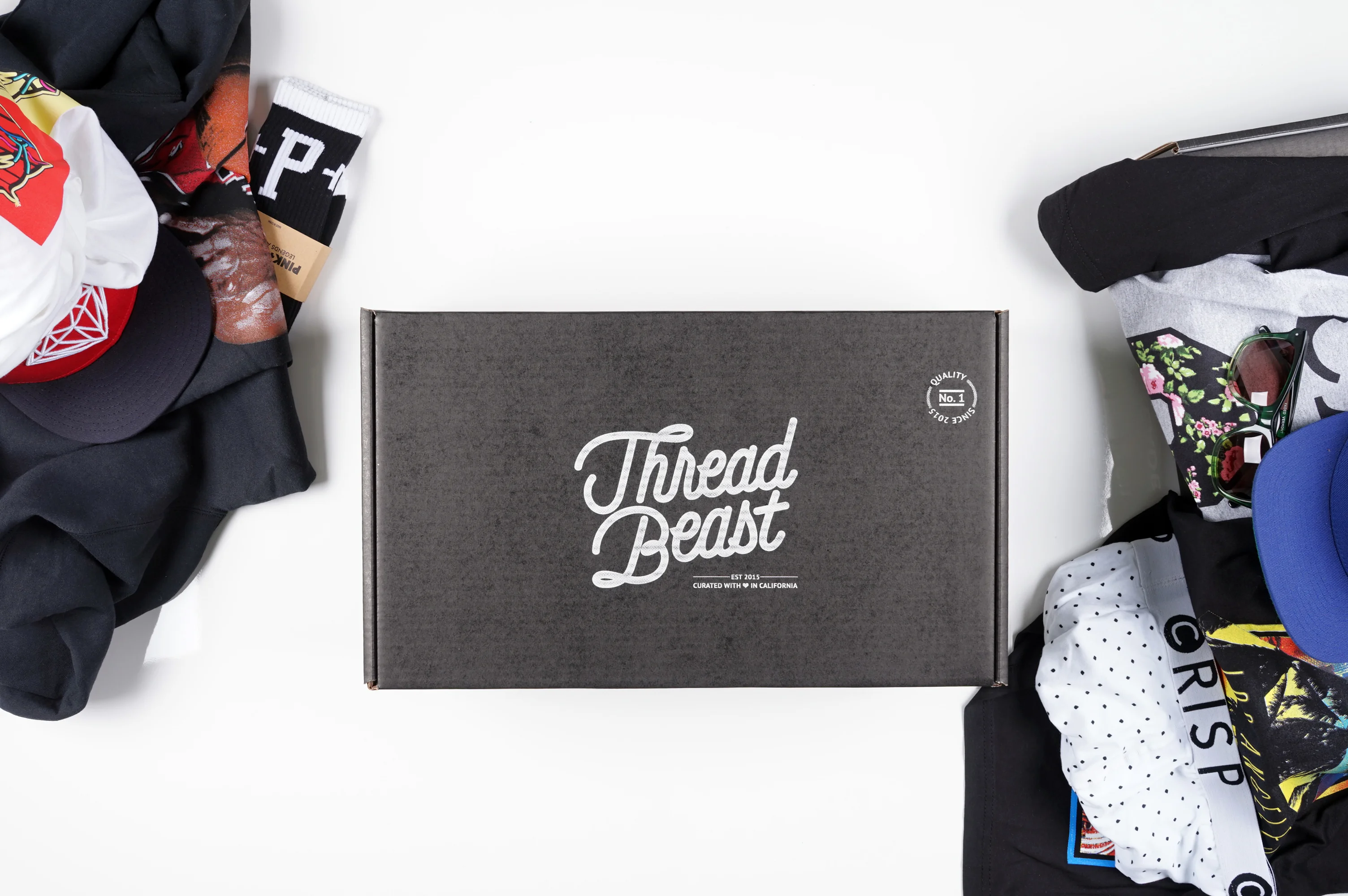 Threadbeast box with clothes layed out around 