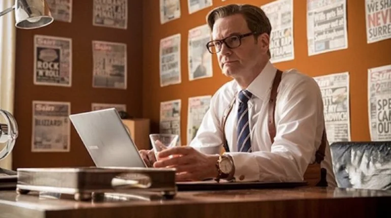 Colin Firth sitting at a desk
