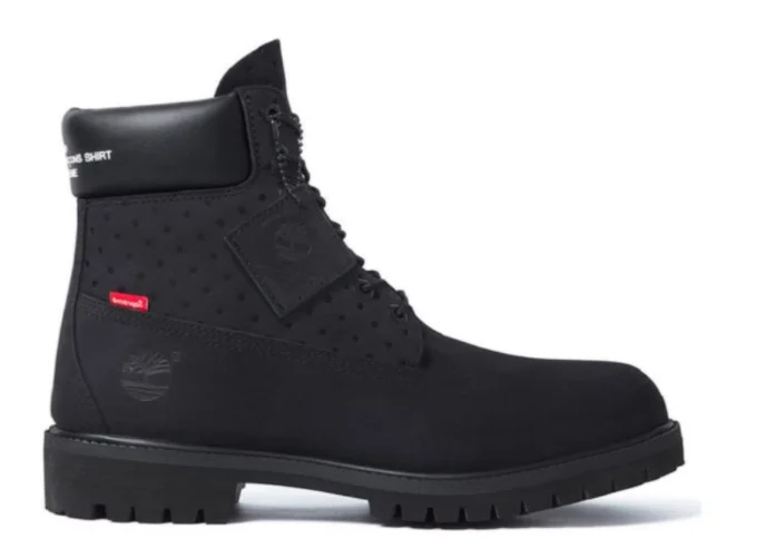 a black timberland boot with supreme and comme des  garcones logo